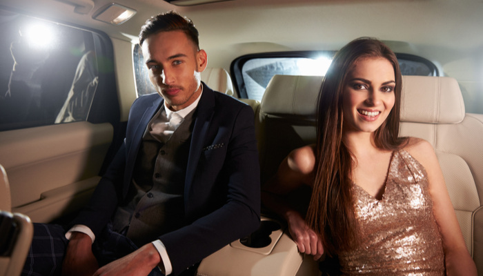 Attractive young couple in the back of a limo for their valentine date